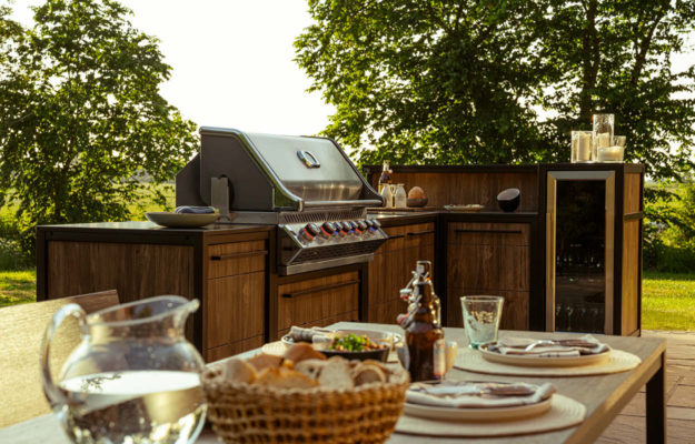 Burnout Küchen: Burnout Küche BBQ in industrieller Optik mit Holz und Metall mit Tisch davor.