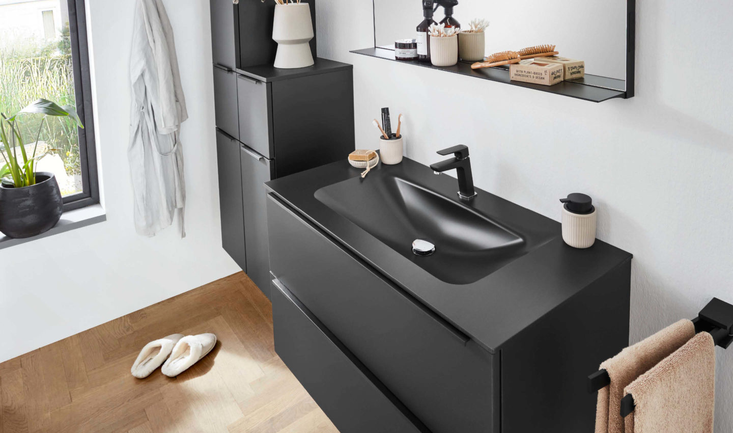 Schwarzes, modernes Badezimmer mit schwarzen Armaturen und schwarzer Spüle.